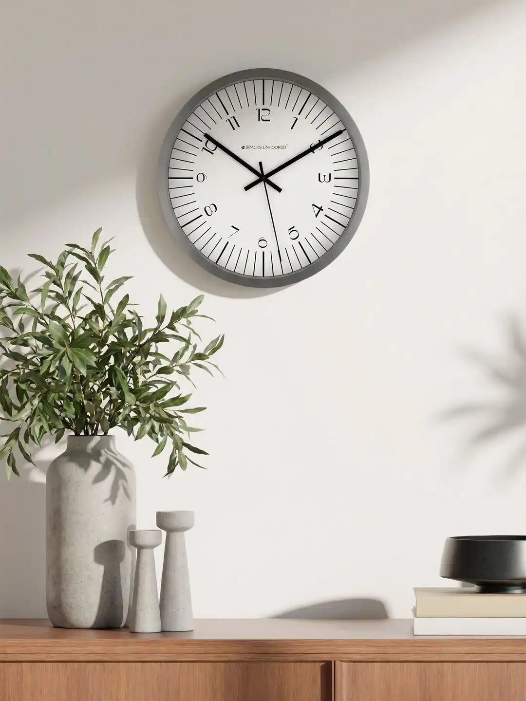 Spaces Unhooked grey silent wall clock displayed on a modern living room wall with contemporary home décor
