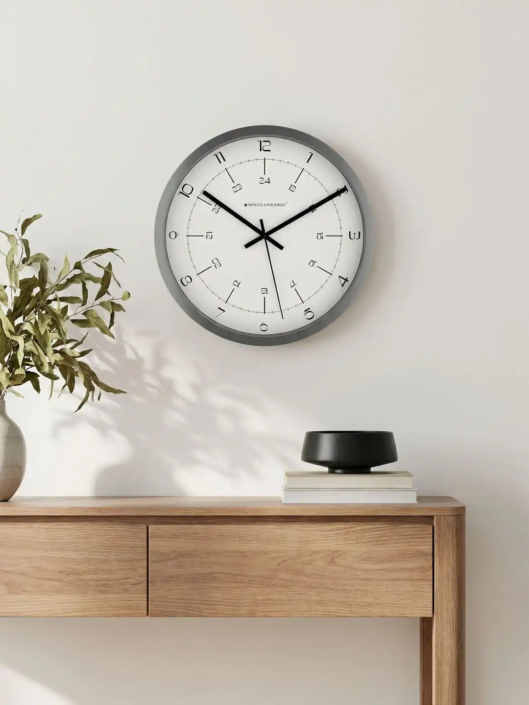 Spaces Unhooked grey silent wall clock displayed in a modern living room with minimalist home décor