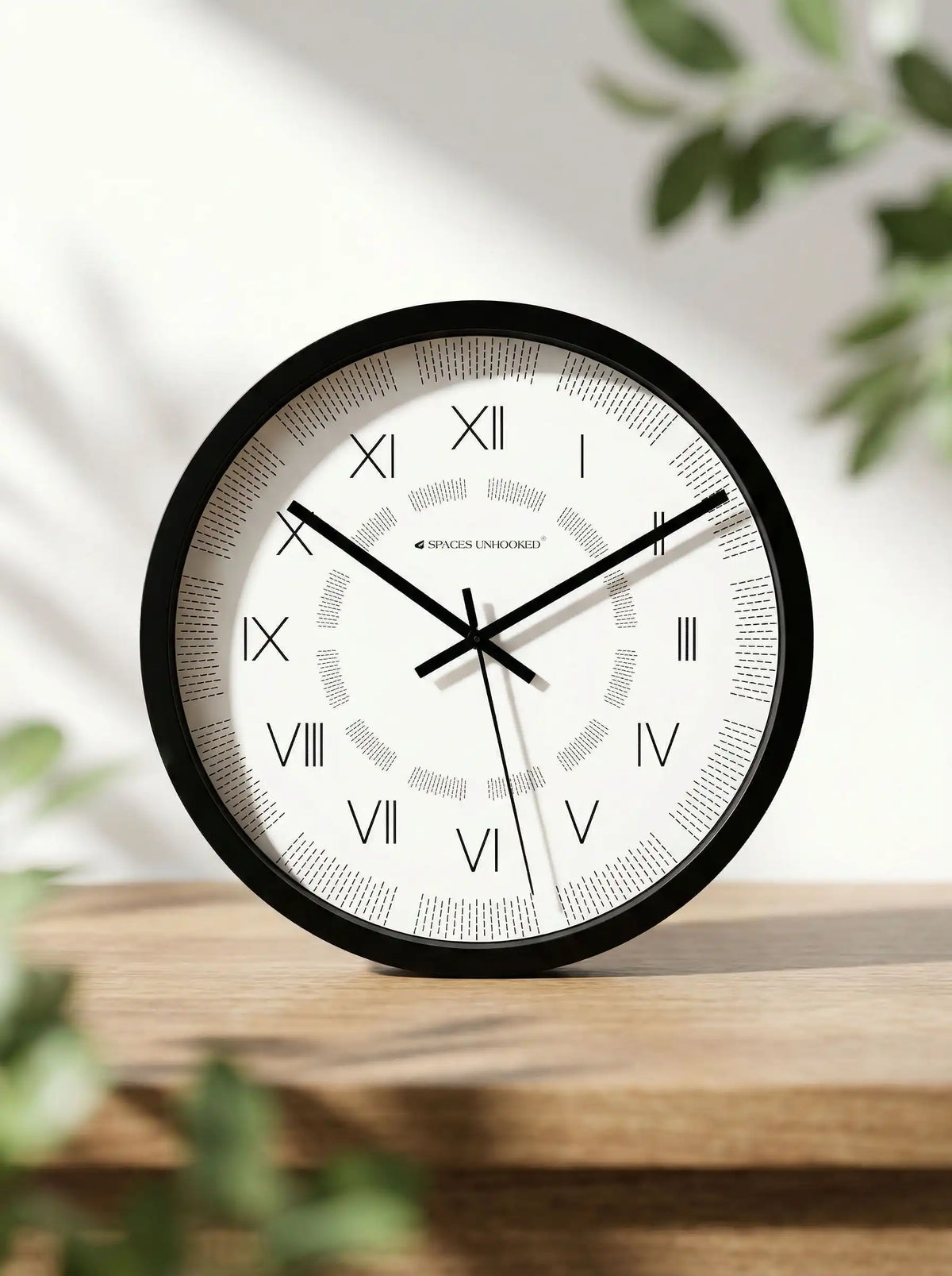 Lifestyle AI View – Premium Silent Black Wall Clock on Wooden Shelf with Green Foliage Decor