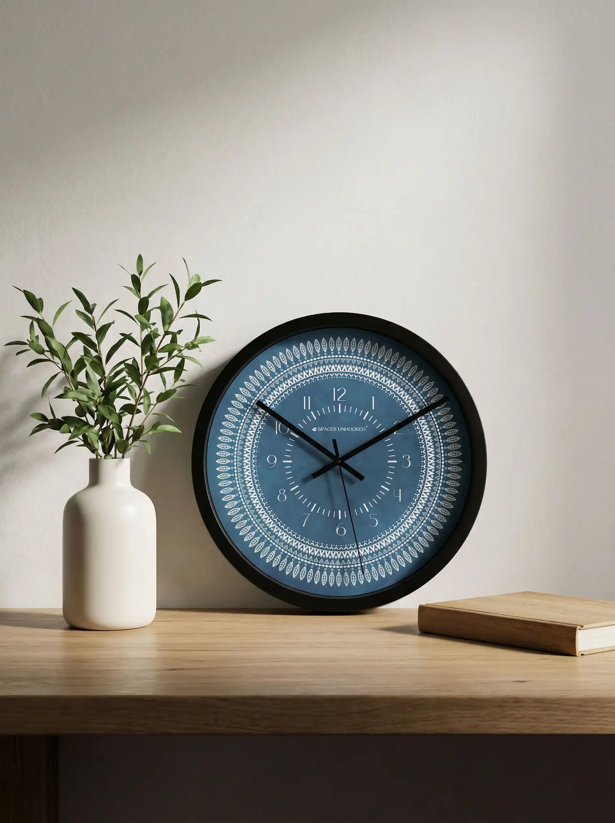 Lifestyle AI – Designer wall clock mounted above sofa with pillows and plant decor