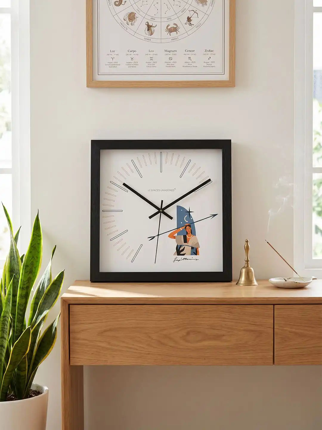 Dimensions chart showing the Sagittarius zodiac wall clock with a square 305 mm frame, displayed against a minimalist interior backdrop.