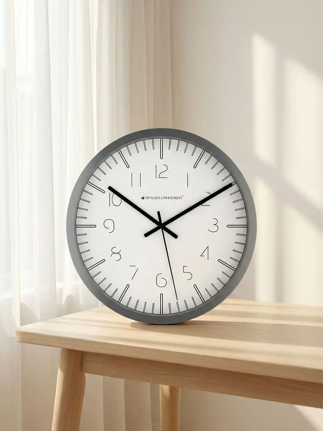 Spaces Unhooked grey minimalist wall clock styled in a bright contemporary living room interior