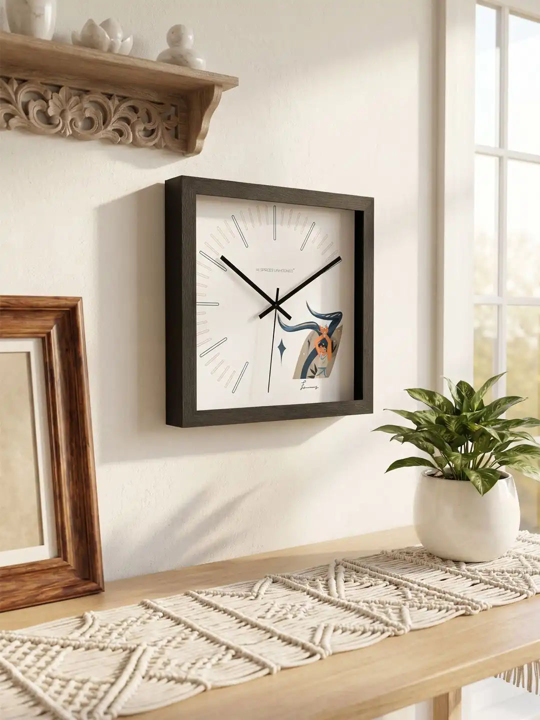 Angled side perspective of a contemporary square wall clock with black wooden frame, minimalist face, and dancer-themed illustration.
