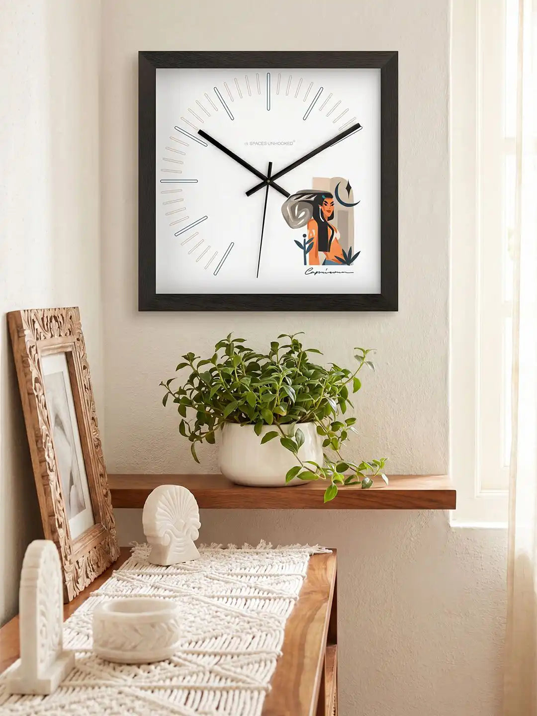 Capricorn zodiac wall clock styled on a console table, decorative wooden wall clock with contemporary Capricorn artwork, elegant interior accessory
