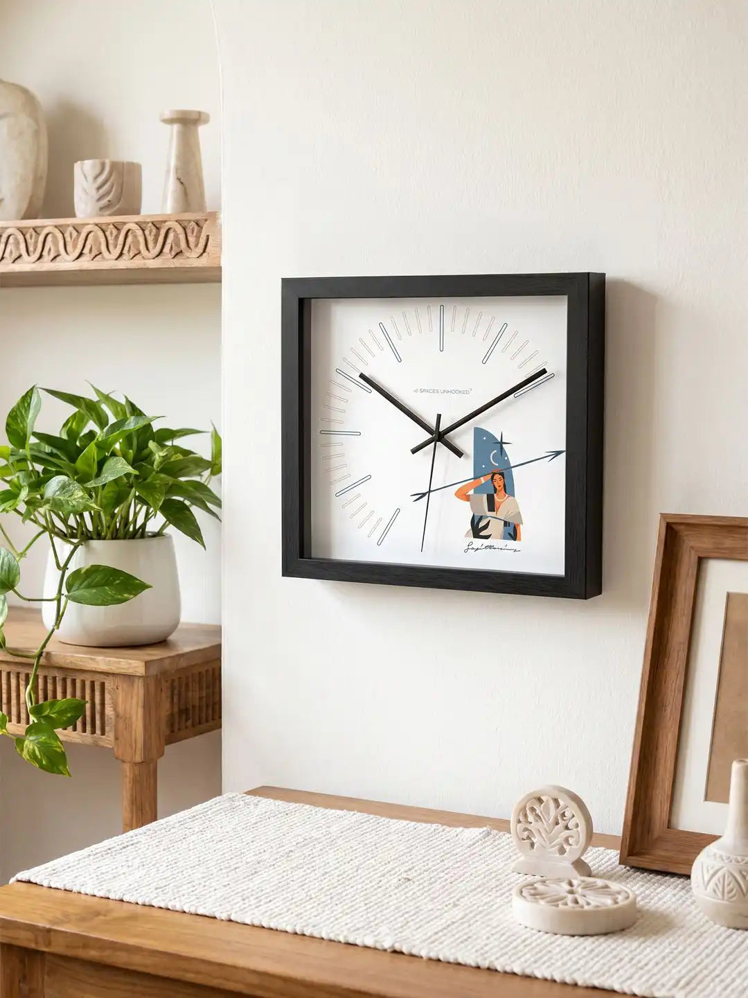 Close-up angled view of the Sagittarius zodiac wall clock featuring a black wooden frame, minimalist hour markers, and sleek black metal hands on a white dial.