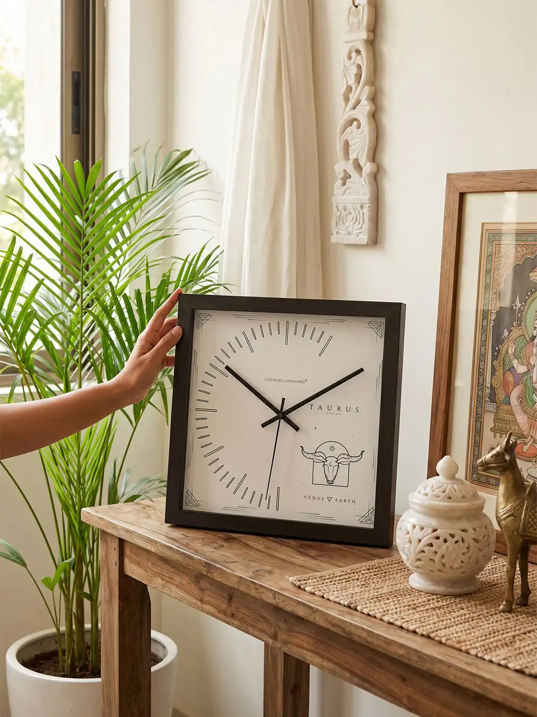 Taurus zodiac wall clock styled on a wooden console table, decorative wooden clock with bull motif, premium home décor accessory