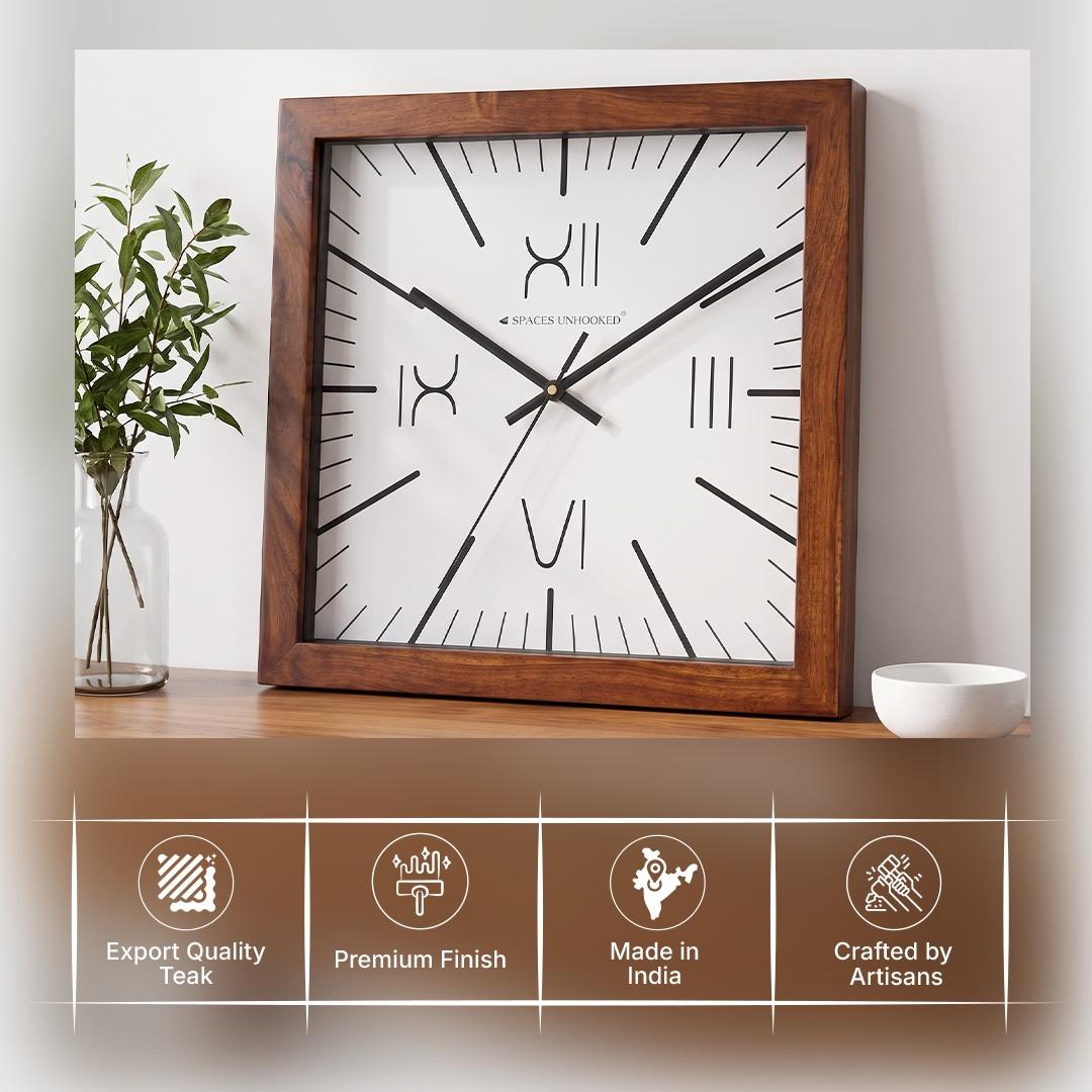 Four Roman numeral wall clock in an entrance hall with framed art and a console table