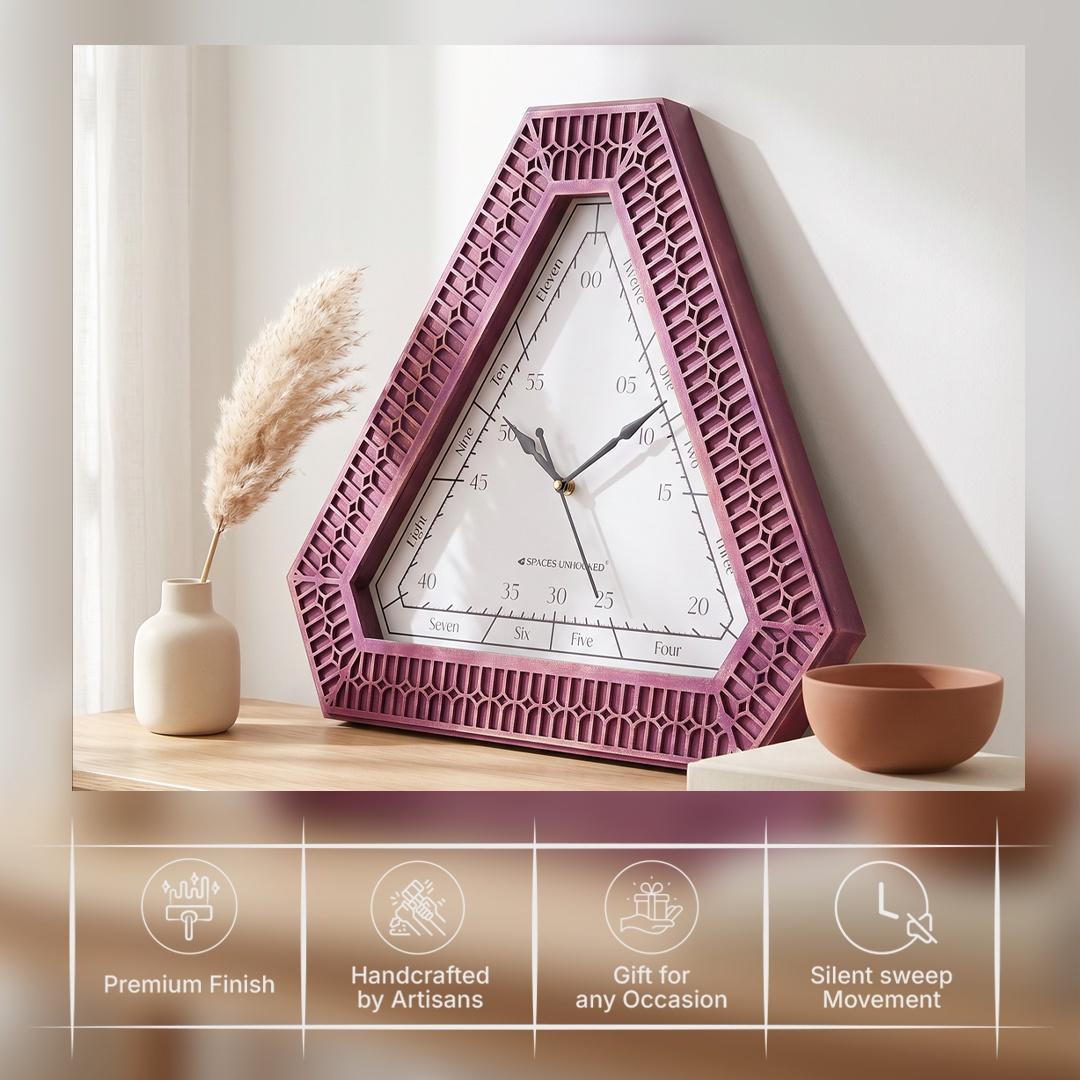 Triangular magenta wall clock on a bedroom wall beside a dresser