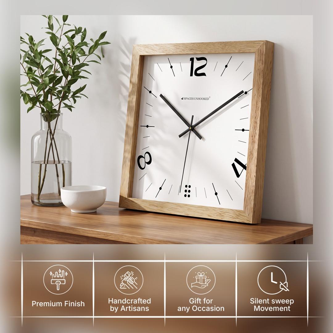 Oak square wooden wall clock on a gallery wall hallway with black frames and plants