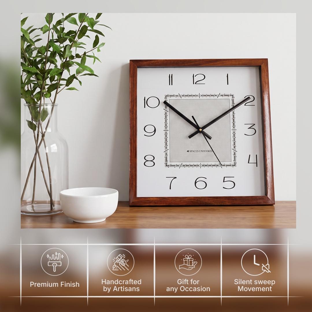 Slim elongated black numerals 1 to 12 on the white dial of a square wooden wall clock