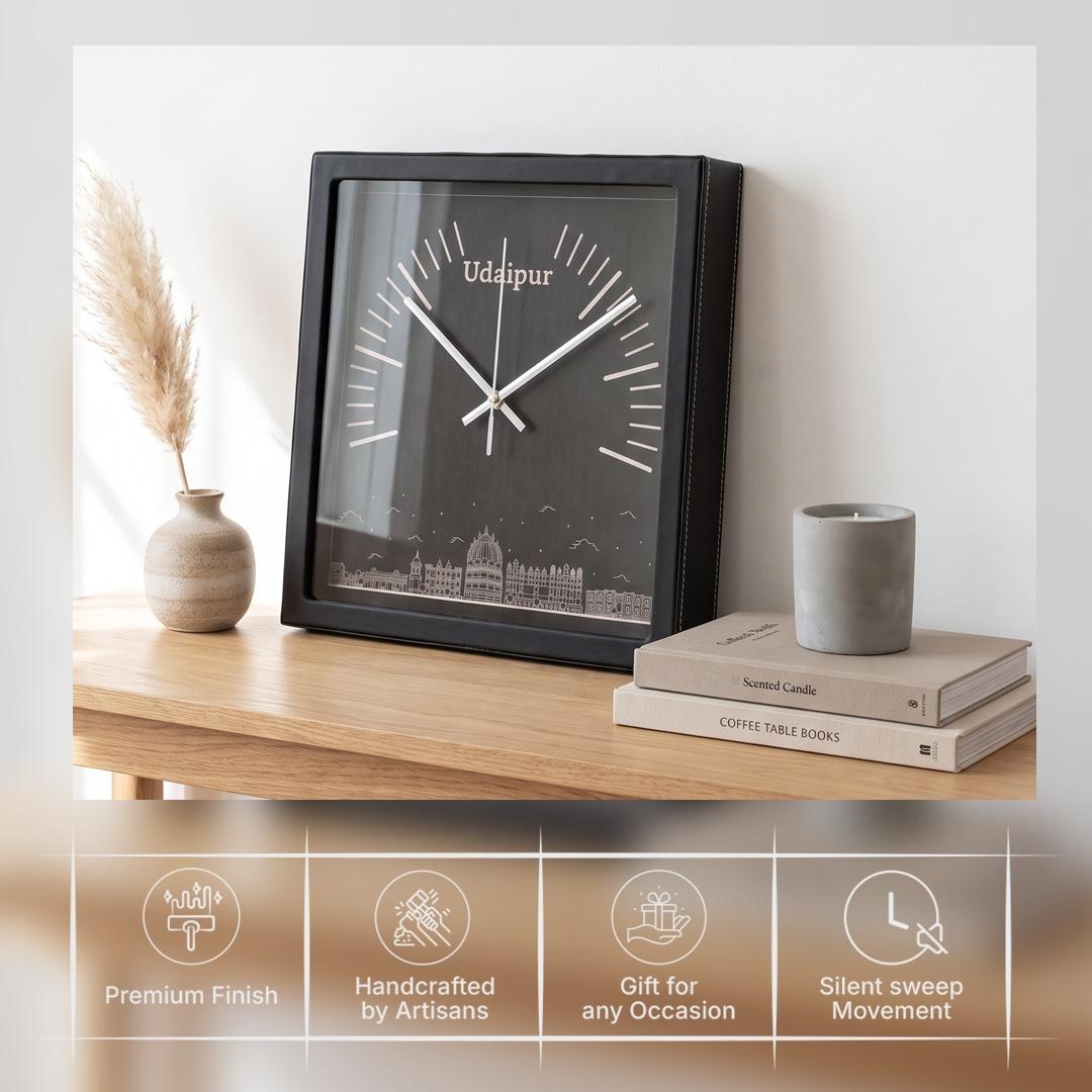 Silver-white hands over white radial markers on a black clock dial