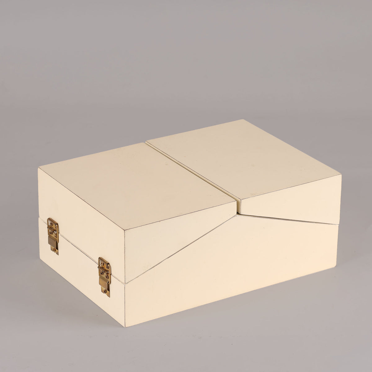 Beige jewelry box with gold clasps on a gray background