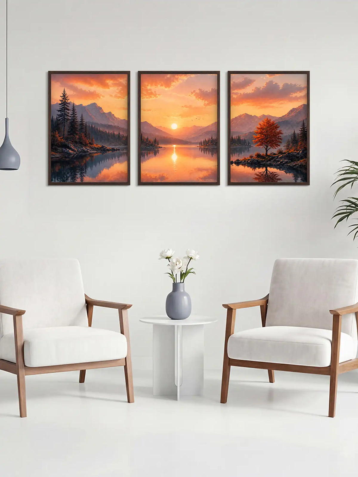 Three framed landscape prints of a sunset over a lake in a living room setting.