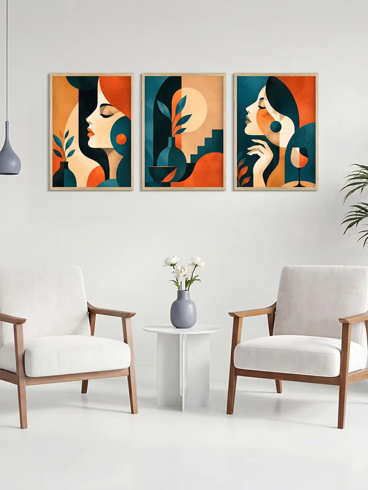 Three abstract art prints of women's faces on a wall above a white table with a vase and flowers, flanked by two chairs.