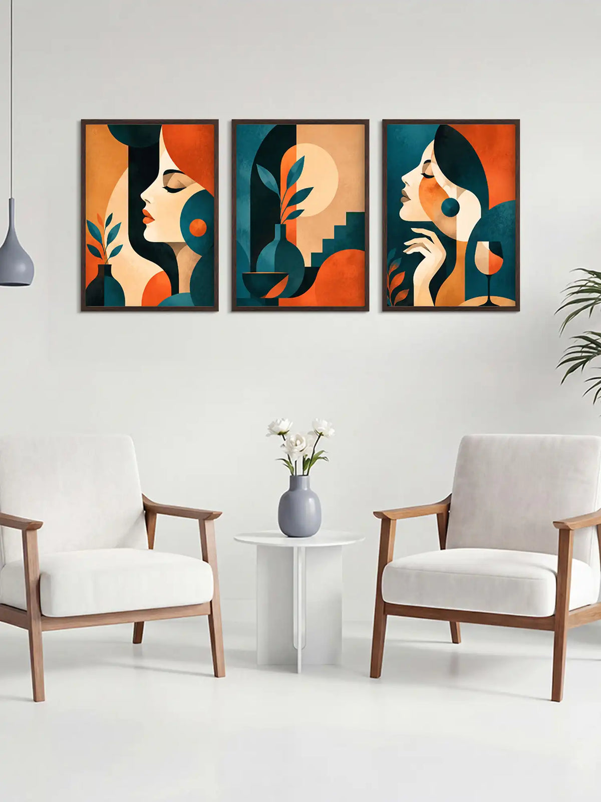Three abstract art prints on a wall above a white table with a vase and flowers, flanked by two chairs.