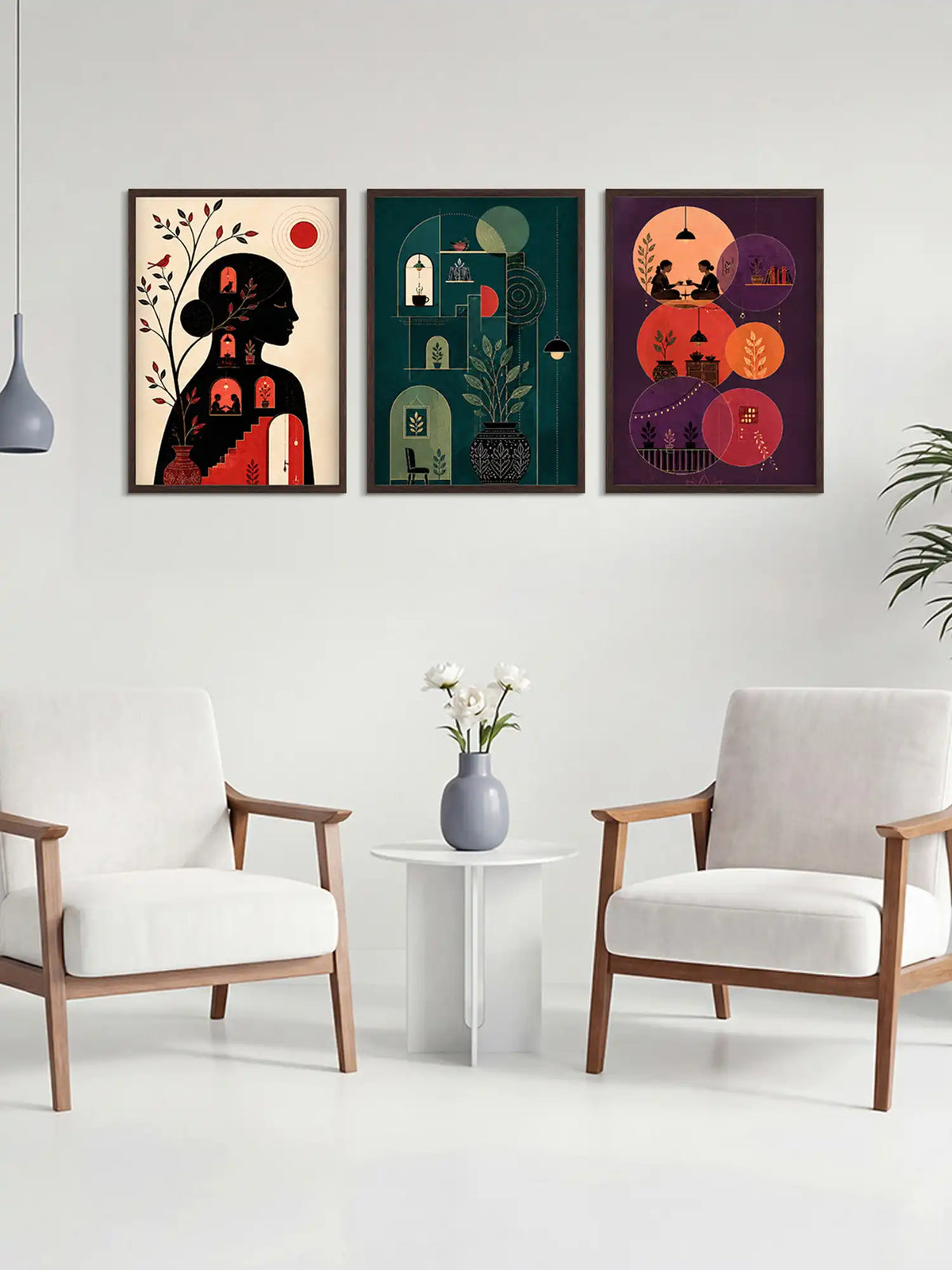 Three colorful framed artworks on a wall above two white chairs and a small table with a vase.